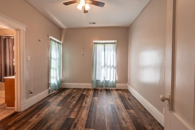 unfurnished room with dark wood-type flooring, ceiling fan, and a wealth of natural light