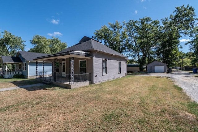 view of home's exterior featuring a lawn, covered porch, an outdoor structure, and a garage