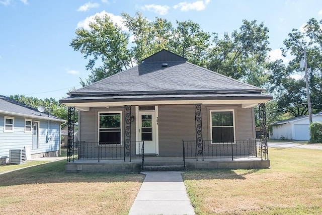 bungalow-style home featuring a front lawn, covered porch, and cooling unit