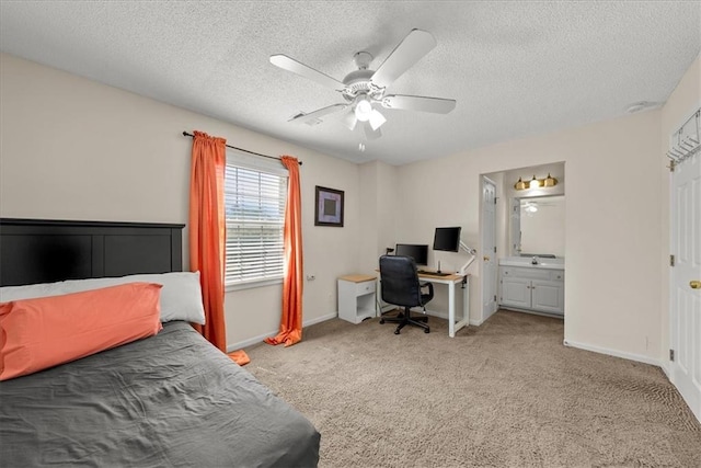 carpeted bedroom with a textured ceiling, connected bathroom, and ceiling fan