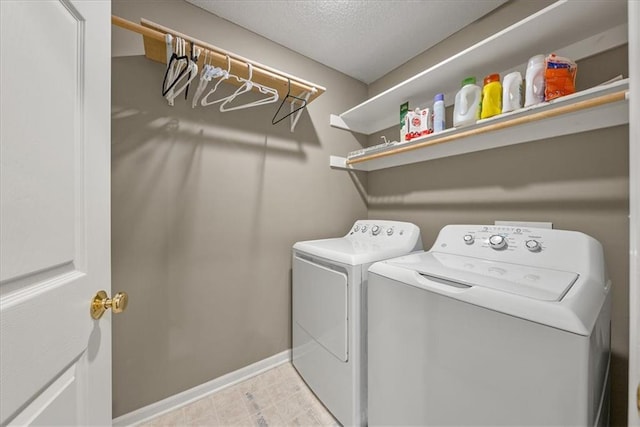 washroom with washing machine and clothes dryer and a textured ceiling