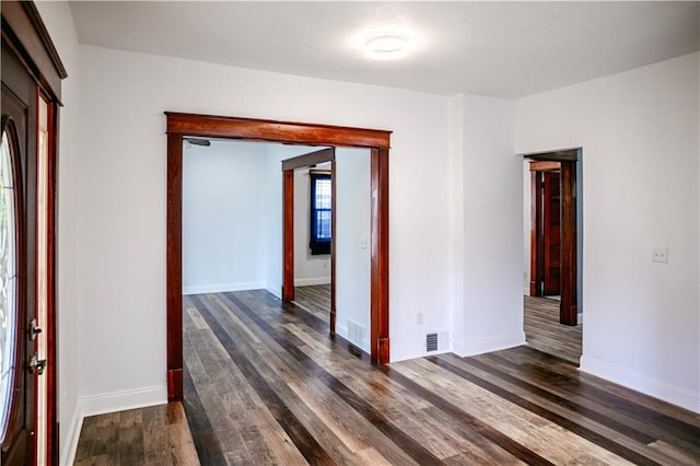 unfurnished room with dark wood-type flooring