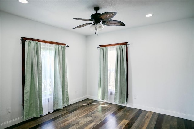 spare room featuring dark wood-type flooring and ceiling fan