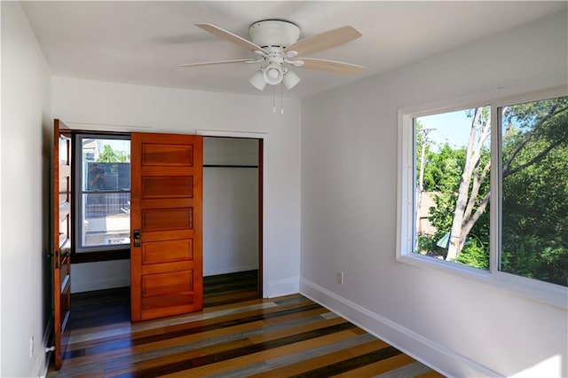 unfurnished bedroom with a closet, ceiling fan, and dark hardwood / wood-style floors