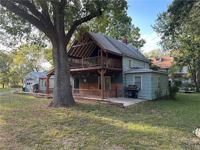 back of house with a lawn, a patio, and a wooden deck