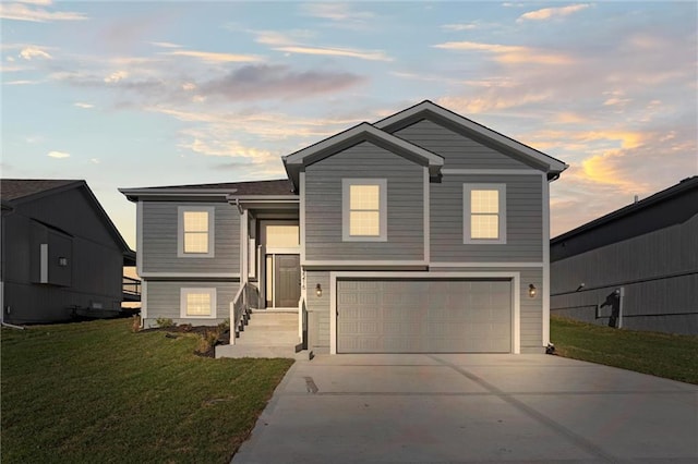 view of front of house featuring a garage and a lawn