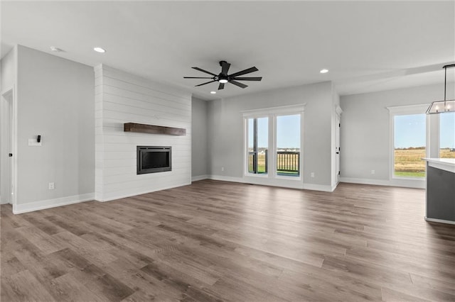 unfurnished living room with hardwood / wood-style floors, a healthy amount of sunlight, and a fireplace