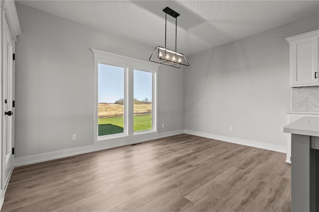 unfurnished dining area featuring light wood-type flooring