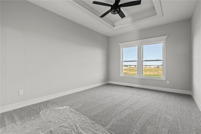 unfurnished room with carpet, ceiling fan, and a tray ceiling