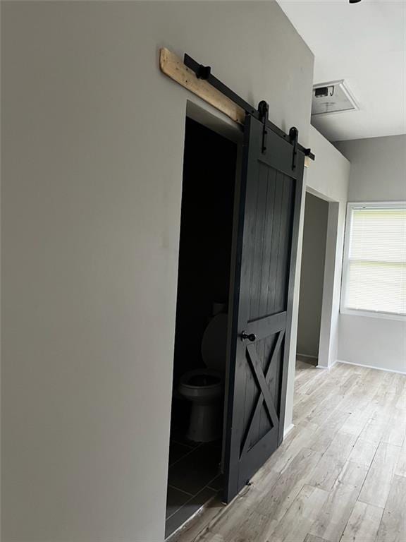 interior space featuring a barn door and light hardwood / wood-style flooring