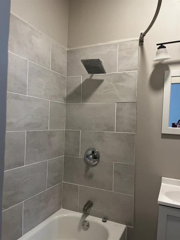 bathroom with tiled shower / bath and vanity