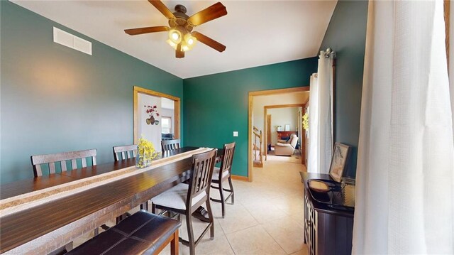 tiled dining space featuring ceiling fan