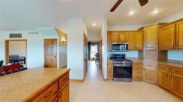 kitchen featuring light tile patterned floors, ceiling fan, and stainless steel appliances