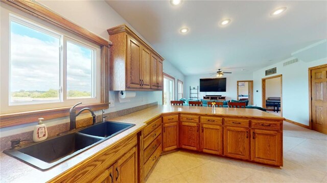 kitchen featuring ceiling fan, sink, and kitchen peninsula