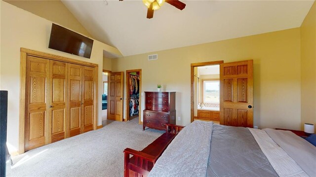 carpeted bedroom featuring a closet, high vaulted ceiling, ensuite bath, a spacious closet, and ceiling fan