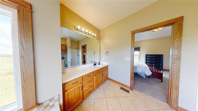 bathroom with lofted ceiling, tile patterned floors, and vanity