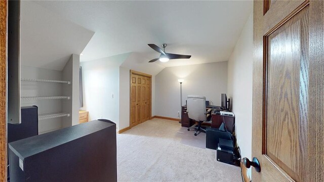 carpeted office space featuring ceiling fan and lofted ceiling