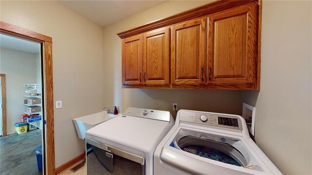 laundry area with sink, washing machine and clothes dryer, and cabinets