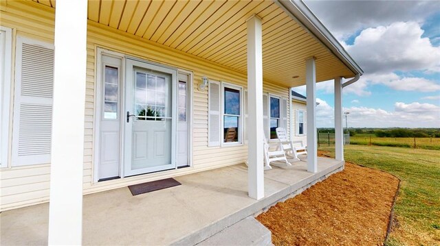 property entrance with a porch and a yard