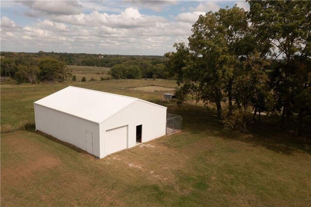 exterior space with a lawn, a rural view, and a garage