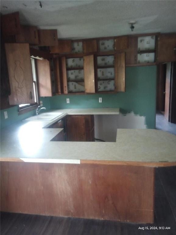 kitchen featuring kitchen peninsula, sink, and hardwood / wood-style floors