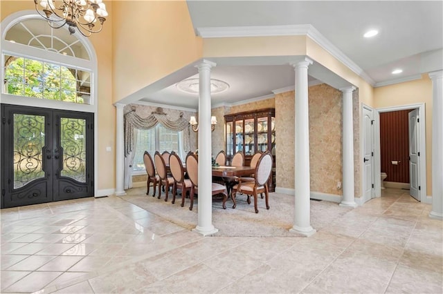 tiled entrance foyer featuring decorative columns, french doors, a chandelier, and a healthy amount of sunlight