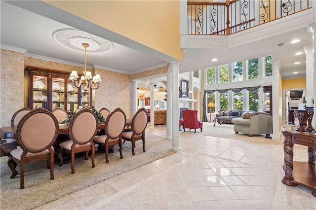 tiled dining space featuring ornamental molding, a towering ceiling, ornate columns, and an inviting chandelier