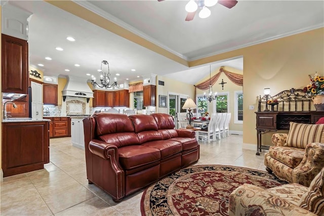 tiled living room with crown molding, sink, and ceiling fan with notable chandelier