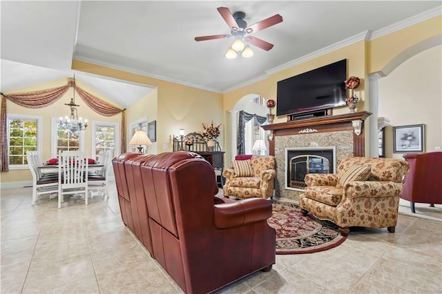 tiled living room with crown molding, a premium fireplace, and ceiling fan with notable chandelier