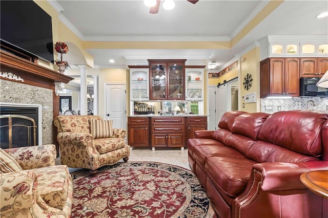 living room with ornamental molding, decorative columns, ceiling fan, and a barn door