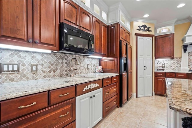 kitchen with white cabinets, tasteful backsplash, light stone counters, and crown molding