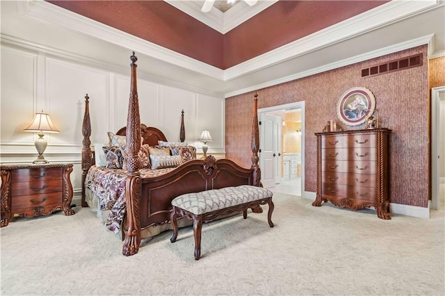 carpeted bedroom with a towering ceiling, ceiling fan, ensuite bathroom, and ornamental molding