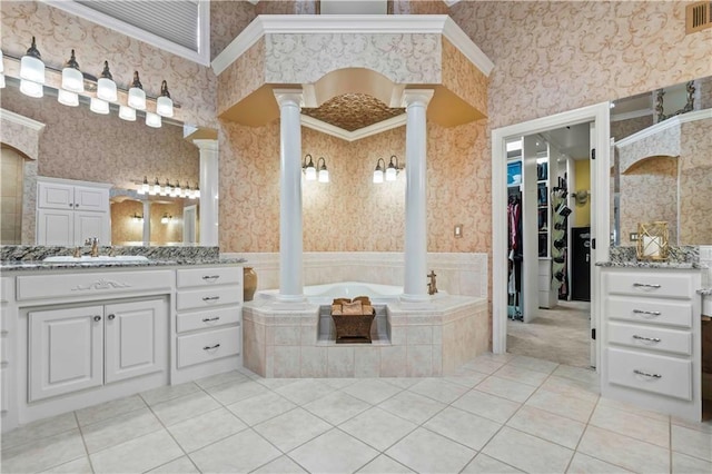 bathroom with vanity, tiled tub, tile patterned floors, and ornate columns