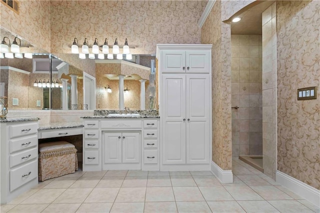 bathroom with tile patterned flooring, walk in shower, decorative columns, and vanity