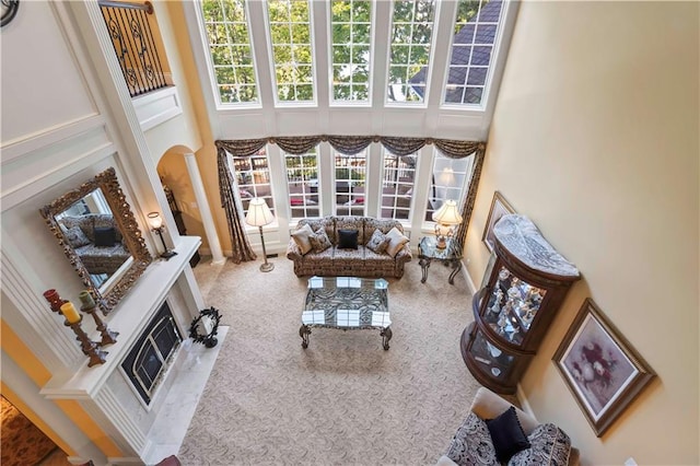 carpeted living room featuring heating unit and a towering ceiling