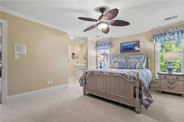 bedroom with ceiling fan, light colored carpet, ornamental molding, and ensuite bath