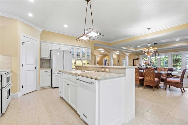 kitchen featuring white appliances, white cabinetry, light tile patterned floors, hanging light fixtures, and a center island with sink