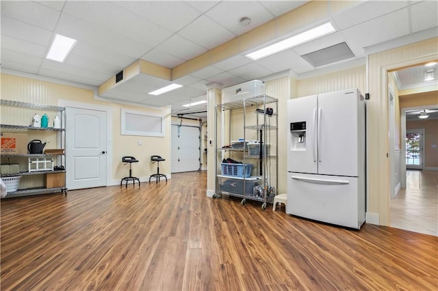 miscellaneous room with a paneled ceiling, a barn door, and hardwood / wood-style flooring