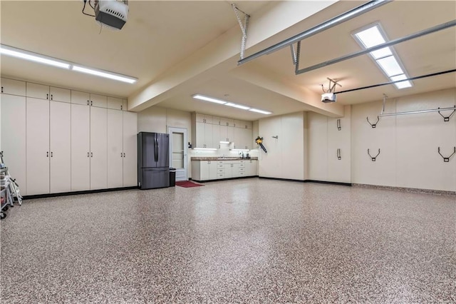 garage featuring stainless steel refrigerator and a garage door opener