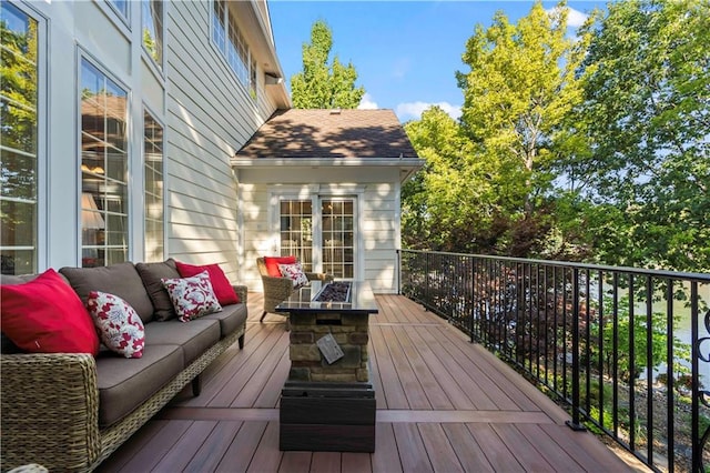 wooden terrace featuring an outdoor living space with a fire pit