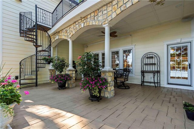 wooden terrace with ceiling fan and a patio area