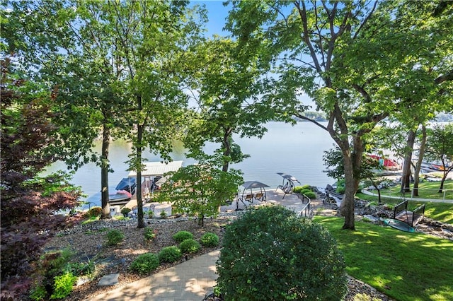 surrounding community with a water view and a lawn