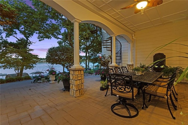 patio terrace at dusk featuring ceiling fan