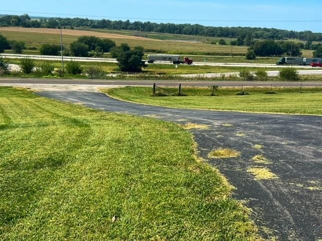 view of home's community with a lawn and a rural view