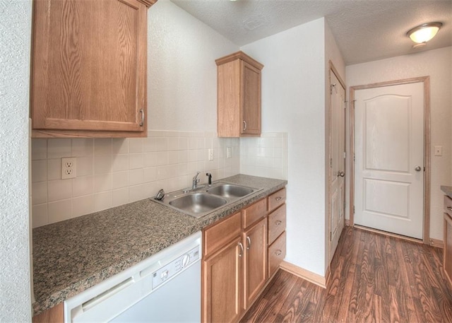 kitchen featuring tasteful backsplash, a textured ceiling, dishwasher, sink, and dark wood-type flooring