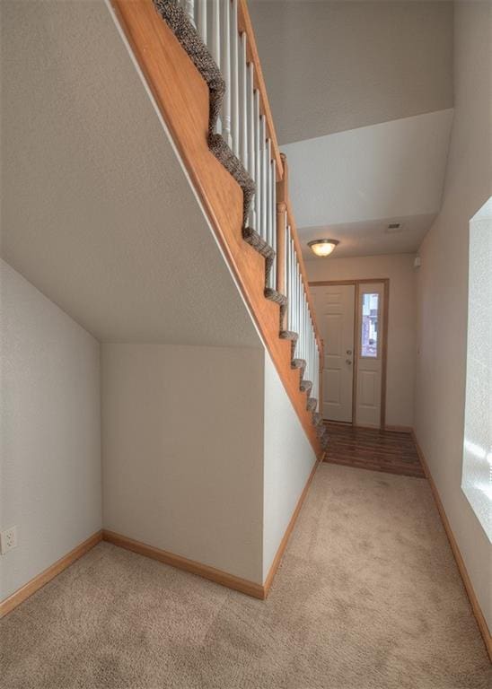 carpeted entrance foyer with lofted ceiling