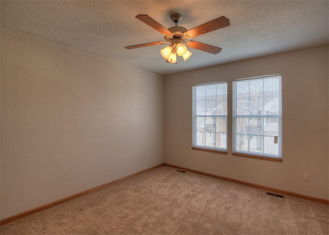 unfurnished room with light colored carpet, a textured ceiling, and ceiling fan