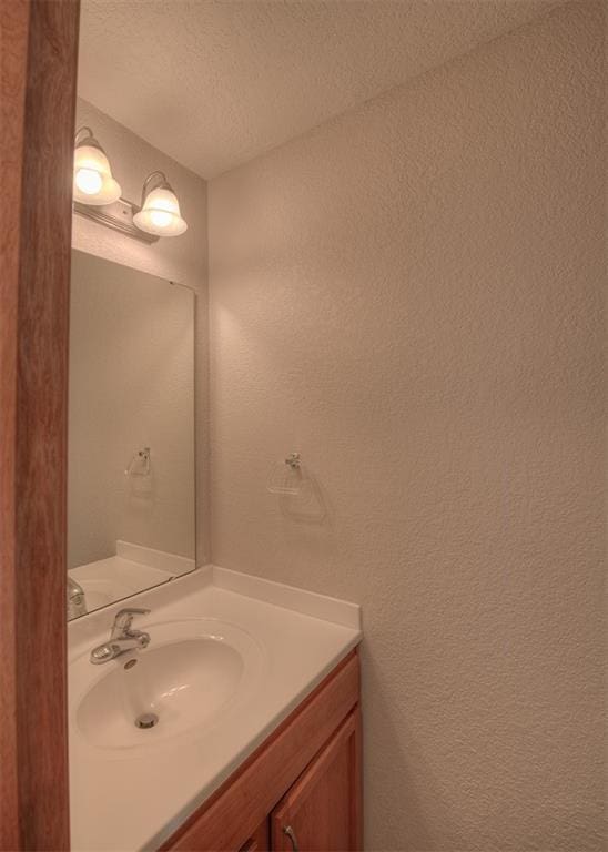 bathroom featuring a textured ceiling and vanity