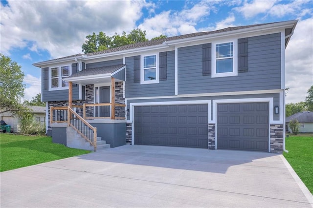 raised ranch featuring a front lawn and a garage