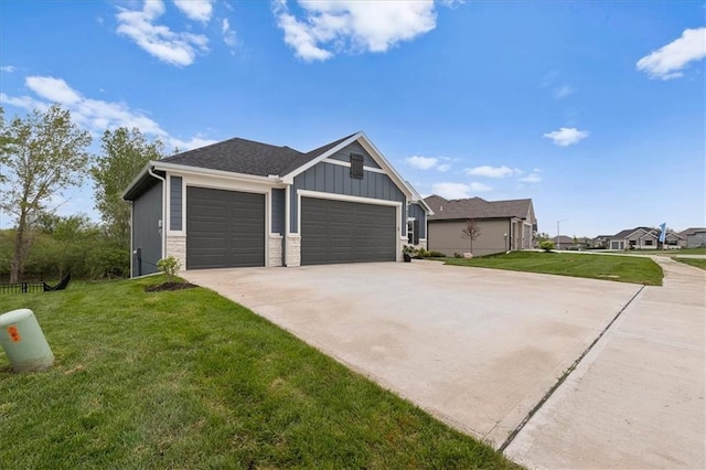 14574 Aurora Ln, Basehor, KS 66007 - view of property exterior featuring a garage, concrete driveway, a lawn, and board and batten siding
